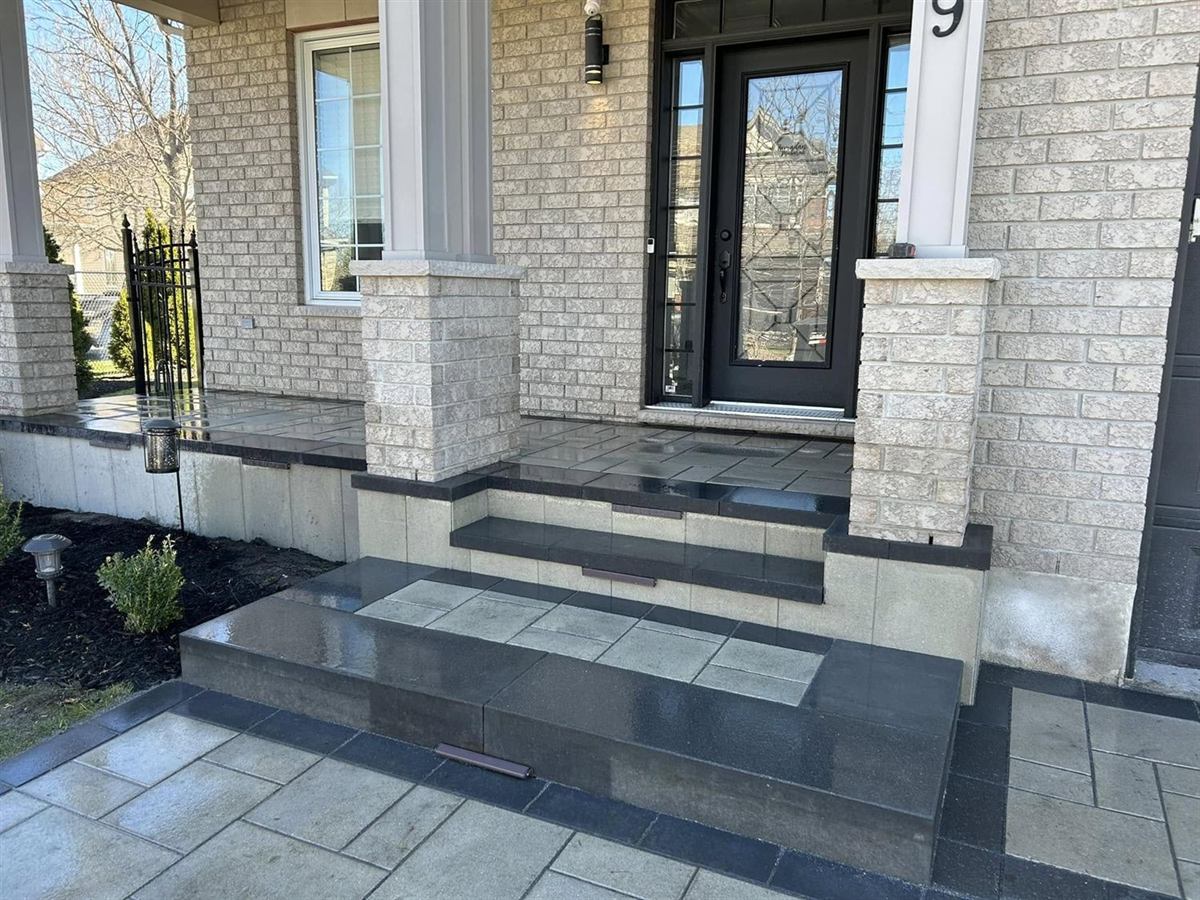 Charcoal slab steps with built-in step lights rising to a front door landing