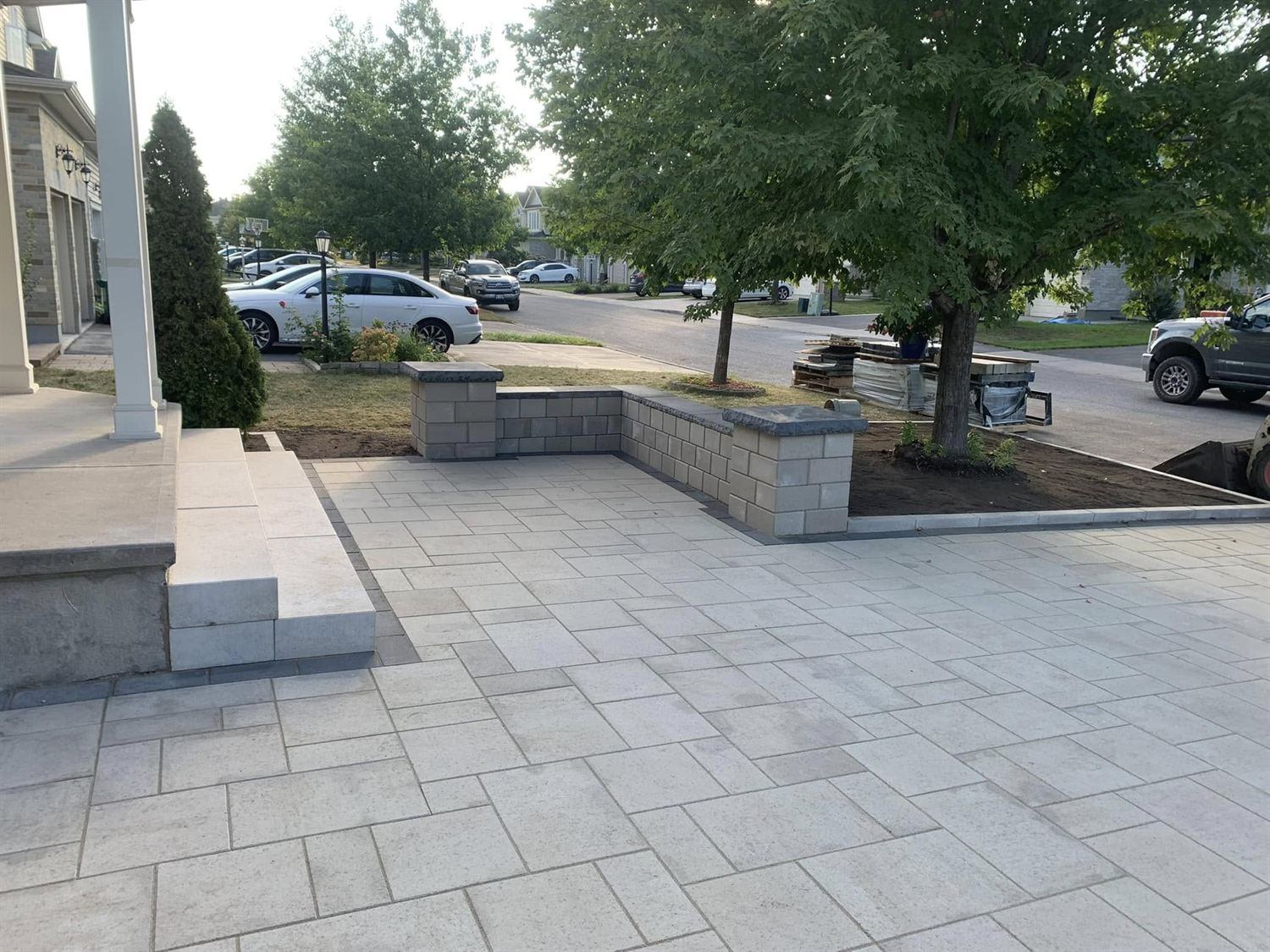 A large-format paver front patio enclosed by a capped block seat wall