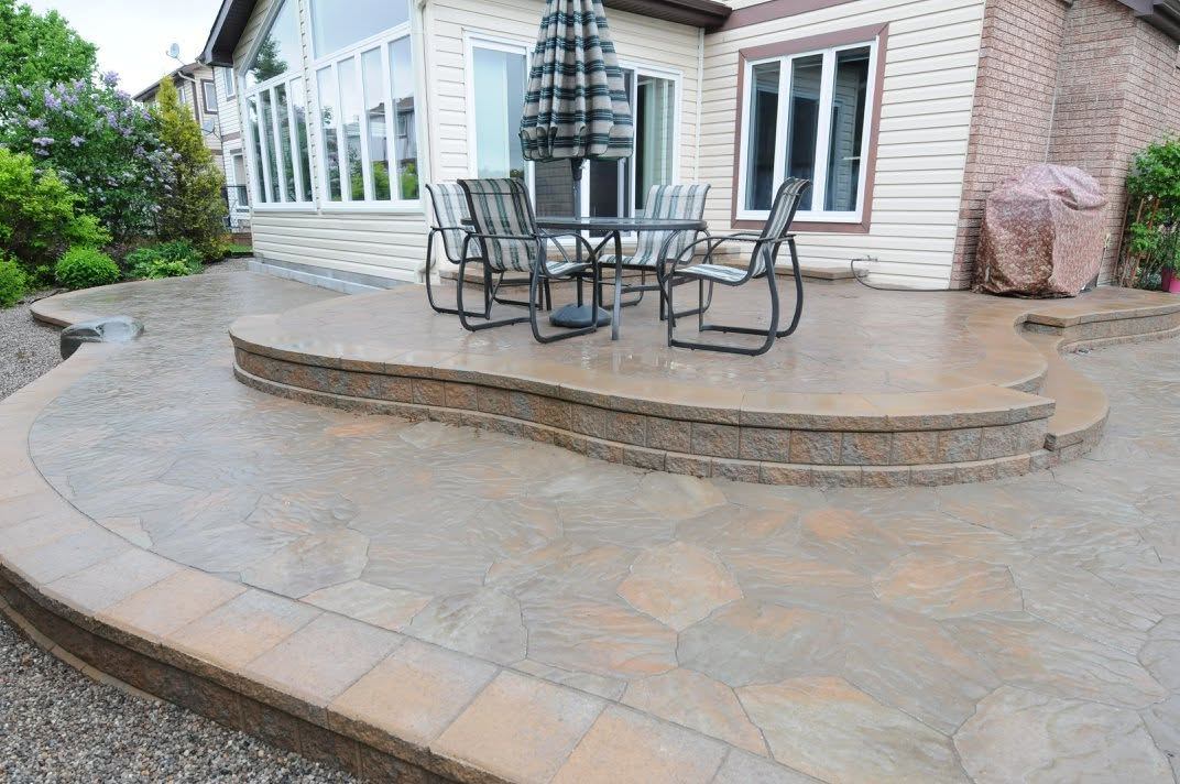 A curved raised flagstone terrace with a seating area above a lower patio